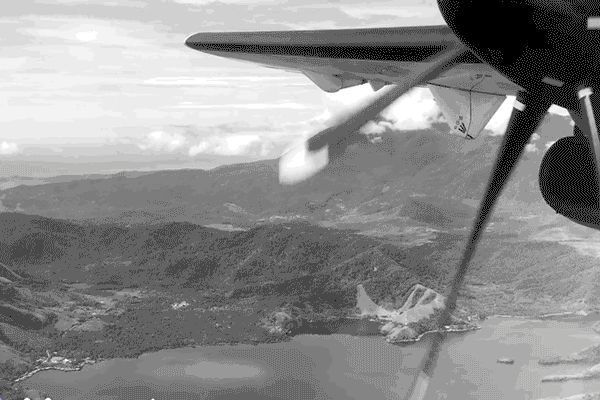 Propellerflugzeug im Flug über den Sentani See