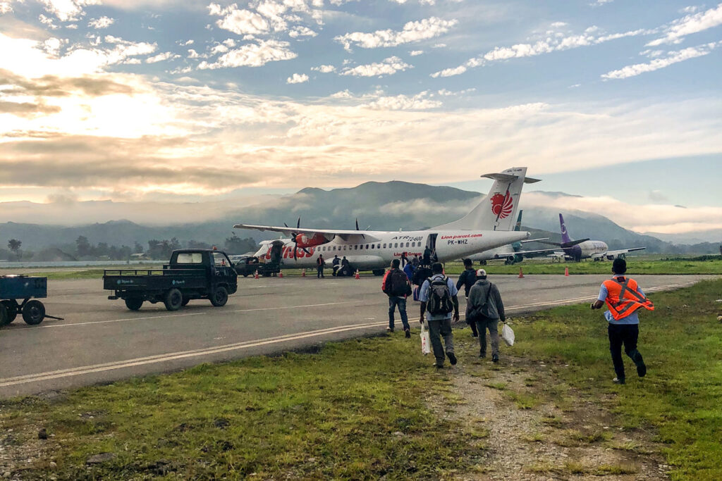 Gruppe Menschen läuft auf ein Flugzeug zu