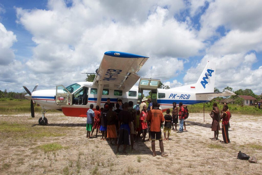 Gruppe von Personen, die vor einem Cessna Caravan Flugzeug stehen