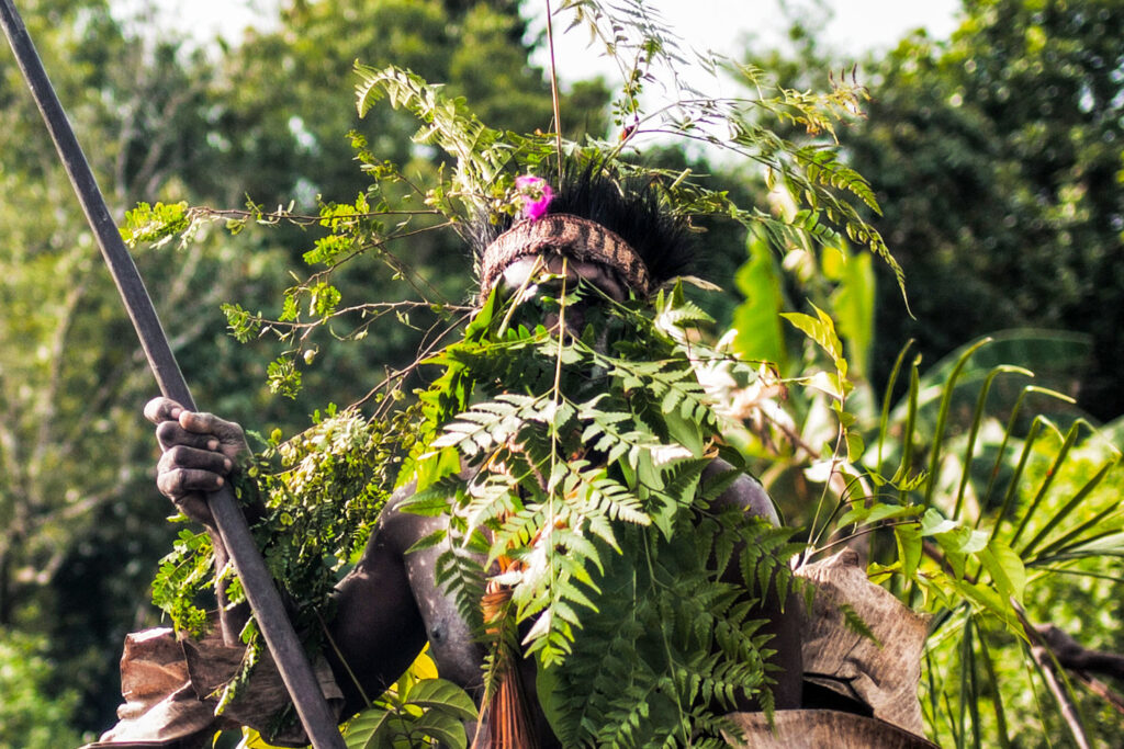 asmat man camouflage leaves decoration frontal portrait